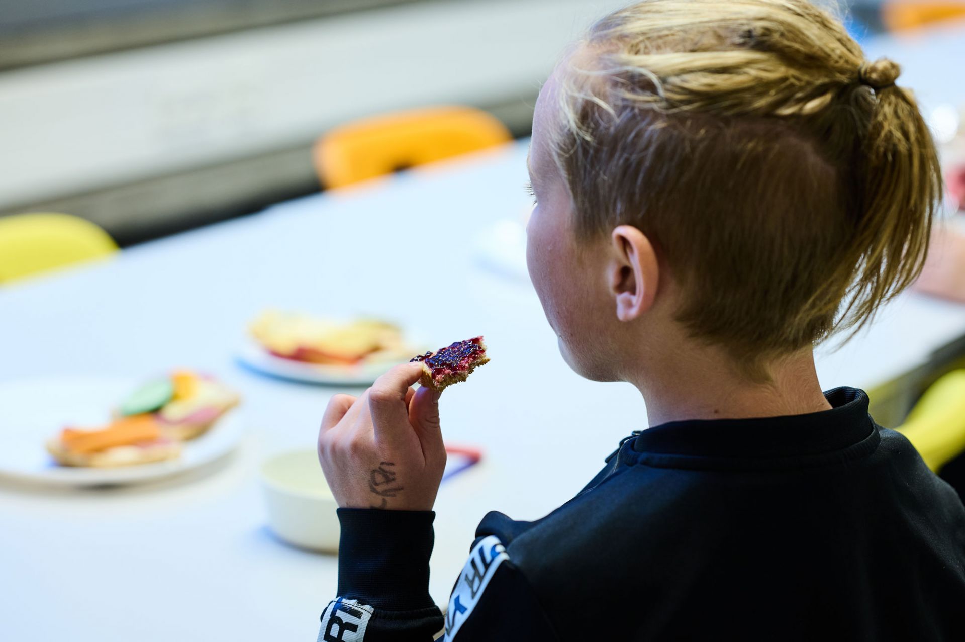 Schüler isst Marmeladenbrot.